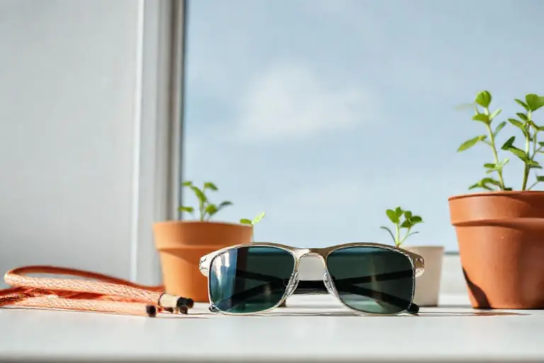 Sportbrille mit beschlagenen Gläsern neben einer Sprühflasche Antibeschlagmittel und einem Mikrofasertuch